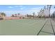 Well-maintained tennis court surrounded by fencing and palm trees at 6209 Lenaking Ave, Las Vegas, NV 89122