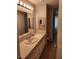 Neutral-toned bathroom with tile countertops, vanity, and mirror at 66 Lailani St, Las Vegas, NV 89110