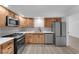 Open kitchen with stainless steel appliances, wooden cabinets, and white countertops at 6741 Bonillo Dr, Las Vegas, NV 89103