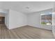 Bright living room with wood-look flooring and a large window with view of greenery at 6741 Bonillo Dr, Las Vegas, NV 89103