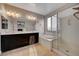 Bright bathroom featuring double sinks, a soaking tub, and a glass-enclosed shower for a spa-like experience at 7311 Spring Flower Ave, Las Vegas, NV 89117