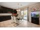 Dining area features modern light fixture, sliding glass door to backyard, fish tank, and tile floors at 7311 Spring Flower Ave, Las Vegas, NV 89117