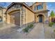 Close-up of a home featuring stone accents, a well-manicured lawn, and a paved walkway to the front door at 7311 Spring Flower Ave, Las Vegas, NV 89117