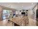 Kitchen island with granite countertops, stainless steel appliances, and a view of the living and dining areas at 7311 Spring Flower Ave, Las Vegas, NV 89117