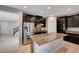Spacious kitchen with stainless steel appliances, a large granite island, and dark cabinetry at 7311 Spring Flower Ave, Las Vegas, NV 89117