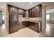 A charming kitchenette with dark cabinets, a black fridge, and ample counter space for easy meal preparation at 7311 Spring Flower Ave, Las Vegas, NV 89117
