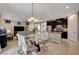 Open-concept living space with dining area, kitchen island, dark cabinets, and a view into the living room at 7311 Spring Flower Ave, Las Vegas, NV 89117