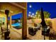 Outdoor patio area with wicker furniture, BBQ grill, string lights, privacy wall and view of pool and spa at 7311 Spring Flower Ave, Las Vegas, NV 89117