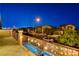 Street view of houses in the neighborhood with manicured landscaping, sidewalks, and city lights in the distance at 7311 Spring Flower Ave, Las Vegas, NV 89117