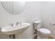 Bathroom features a pedestal sink and a toilet with a tiled floor at 7525 Royal Crystal St, Las Vegas, NV 89149