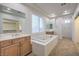 A luxurious bathroom featuring double vanities and a large soaking tub with tile surround at 7525 Royal Crystal St, Las Vegas, NV 89149