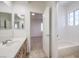 Bathroom featuring vanity with sink and mirror, shower-tub combo with white tile surround at 7525 Royal Crystal St, Las Vegas, NV 89149