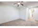 Neutral bedroom featuring carpeting, a ceiling fan, closet, and doorway to adjacent room at 7525 Royal Crystal St, Las Vegas, NV 89149