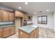 Spacious kitchen featuring a central island, granite counters, stainless appliances and wooden cabinets at 7525 Royal Crystal St, Las Vegas, NV 89149