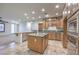 Open kitchen with a large island, granite countertops, wooden cabinetry, and modern appliances at 7525 Royal Crystal St, Las Vegas, NV 89149