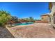 Backyard pool area with brick patio, landscaping, and surrounding privacy wall at 7525 Royal Crystal St, Las Vegas, NV 89149