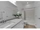 Bathroom featuring a white vanity with a gray countertop, a large mirror, and a shower-tub combo at 7775 Santos Bay Ct, Las Vegas, NV 89179
