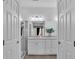 Bright bathroom featuring double doors, modern lighting, and vanity with ample counter space at 7775 Santos Bay Ct, Las Vegas, NV 89179