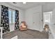 Comfortable bedroom with a chair, floral curtains, and carpet flooring at 7775 Santos Bay Ct, Las Vegas, NV 89179
