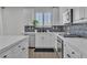 Galley kitchen featuring stainless appliances, modern hardware, backsplash, and quartz countertops at 7775 Santos Bay Ct, Las Vegas, NV 89179