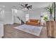 Bright living room with wood flooring, ceiling fan, stylish rug, and a cozy leather sofa at 7775 Santos Bay Ct, Las Vegas, NV 89179