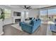 Bright living room with hardwood floors, a black fan, and large windows for natural light at 7775 Santos Bay Ct, Las Vegas, NV 89179