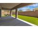 Spacious covered patio overlooking an outdoor area with artificial grass and lounge chairs at 7775 Santos Bay Ct, Las Vegas, NV 89179