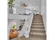 Bright, open two-story foyer features a carpeted staircase, white railings, and a view to the living area at 7775 Santos Bay Ct, Las Vegas, NV 89179