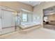 Luxurious bathroom featuring a large soaking tub, separate shower, and abundant natural light from bay window at 8229 Sedona Sunrise Dr, Las Vegas, NV 89128
