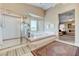 Bright bathroom featuring tub, shower, and picturesque windows overlooking the landscape at 8229 Sedona Sunrise Dr, Las Vegas, NV 89128