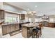 Inviting kitchen with granite countertops, breakfast bar seating, and view of the open-concept living area at 8229 Sedona Sunrise Dr, Las Vegas, NV 89128