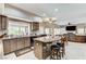 Modern open-concept kitchen featuring an island with seating, granite countertops, and stainless steel appliances at 8229 Sedona Sunrise Dr, Las Vegas, NV 89128