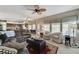 Spacious living room with an adjacent kitchen, cozy armchairs and natural lighting at 8229 Sedona Sunrise Dr, Las Vegas, NV 89128