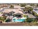 Drone view of a backyard with a pool, hot tub, covered patio, and lush garden areas at 8713 Long Winter Ct, Las Vegas, NV 89131
