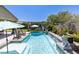 Beautiful pool with sculpted lion statues, lush landscaping, outdoor seating, and patio umbrellas at 8713 Long Winter Ct, Las Vegas, NV 89131