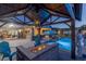 Stylish backyard with a pool, outdoor kitchen, dining area, gazebo with fire pit, and manicured landscaping at 8713 Long Winter Ct, Las Vegas, NV 89131