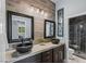 Bathroom showcasing dual vessel sinks, designer mirrors, and wood-like accent wall at 8713 Long Winter Ct, Las Vegas, NV 89131