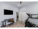 Bright room featuring a desk, television, elliptical machine, and neutral color palette at 8713 Long Winter Ct, Las Vegas, NV 89131