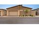 Contemporary home featuring a two-car garage with stone accents and desert landscaping at 912 Allister Fields Ln, Las Vegas, NV 89138