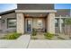 Charming front porch with blue door, stone columns, brick floor and a cozy seating area at 912 Allister Fields Ln, Las Vegas, NV 89138
