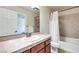 Bathroom featuring a vanity with cherry-toned cabinets, a toilet, and a shower-tub combo at 9628 Matanzas Creek Ct, Las Vegas, NV 89139