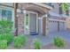 Charming front entrance features a stone archway and well-maintained landscaping, plus three-car garage at 9628 Matanzas Creek Ct, Las Vegas, NV 89139