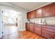 Hallway with hardwood floors and cherry wood cabinets leading to the ensuite bath with tub at 9628 Matanzas Creek Ct, Las Vegas, NV 89139