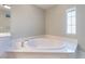 Elegant bathroom featuring a soaking tub with marble surround and soft lighting at 9883 Russian Hill St, Las Vegas, NV 89141