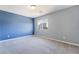 Bedroom with blue accent wall, neutral carpeting and walls, and a window at 9883 Russian Hill St, Las Vegas, NV 89141