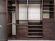 Walk-in closet with dark wood shelving and ample storage space at 9883 Russian Hill St, Las Vegas, NV 89141