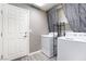 Functional laundry room features a washer, dryer, storage shelves, and a door to the outside at 9883 Russian Hill St, Las Vegas, NV 89141