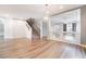 Open concept living room with hardwood floors, staircase, and modern light fixture at 9883 Russian Hill St, Las Vegas, NV 89141