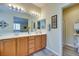 Well-lit bathroom featuring a double sink vanity, large mirror, and step-in shower at 1000 Via Canale Dr, Henderson, NV 89011