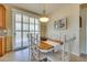 Charming dining area with a wood table, white chairs, and sliding glass door at 1000 Via Canale Dr, Henderson, NV 89011